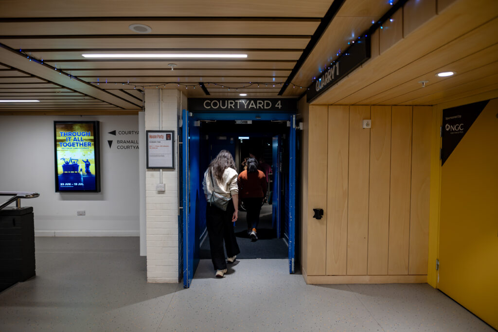 Non-slip, non-reflective flooring in a theatre foyer with colour contrast to the walls and a smooth join to the next surface.