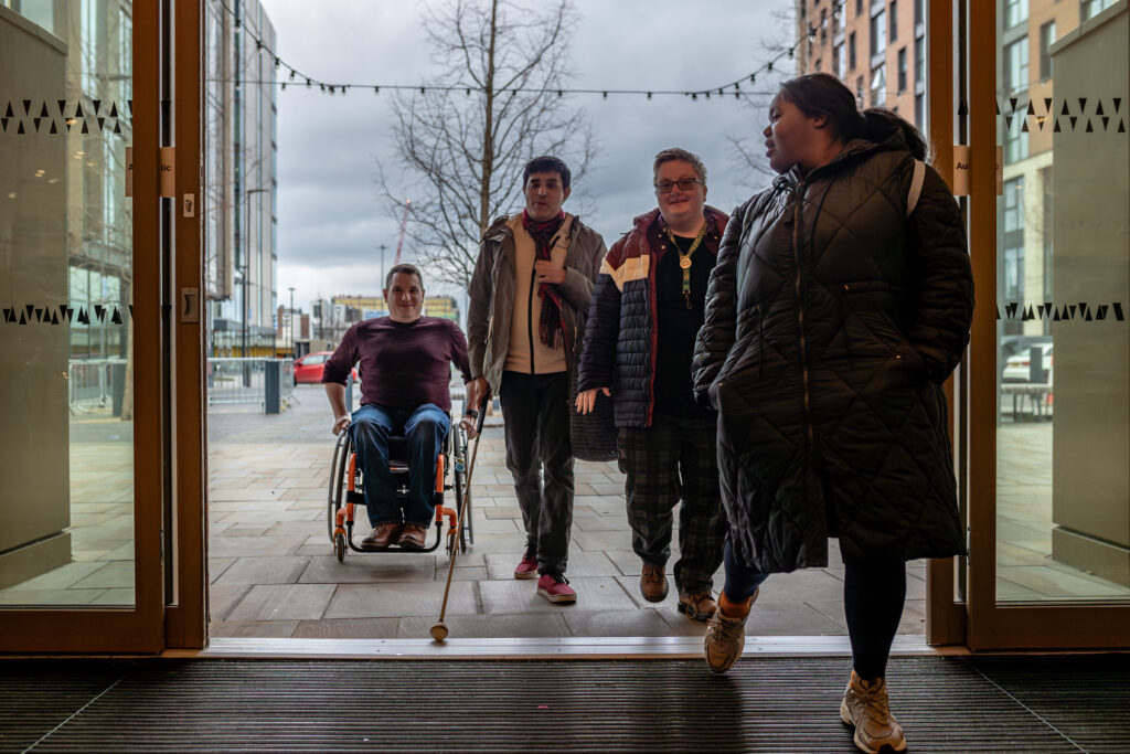 Staff use an accessible entrance into a venue. It has automatic doors and level access.